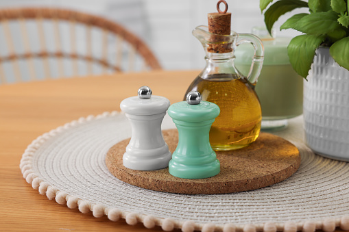Salt and pepper shakers and bottle of oil on wooden table