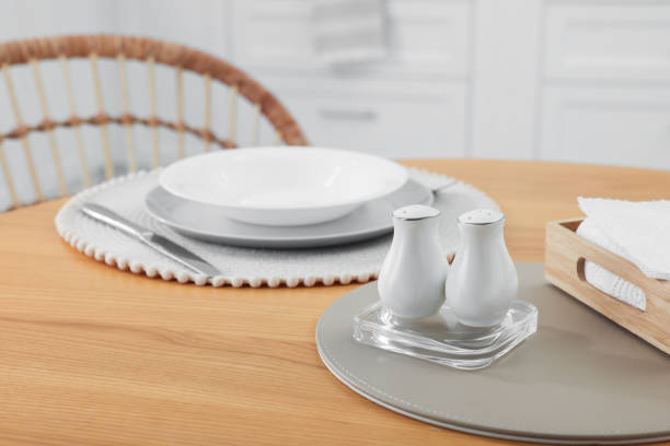 istock White ceramic salt and pepper shakers on wooden table in kitchen, space for text 1475125137