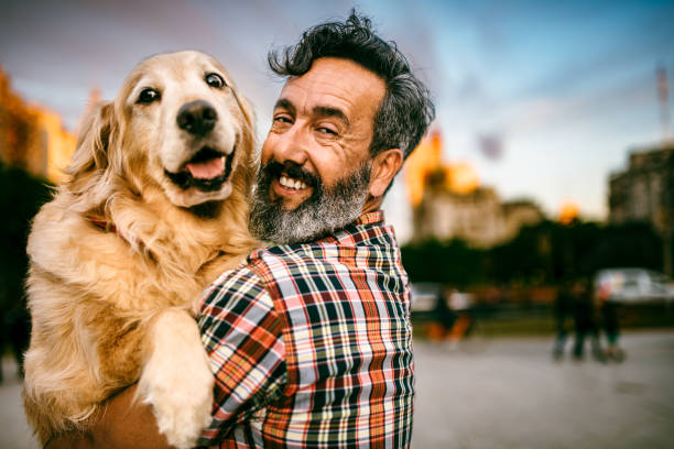 istock Mature man hugs golden retriever 1475128221