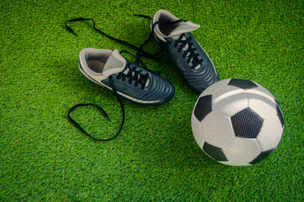 istock Ready for Victory: Boots and Ball on the Pitch 1475129285