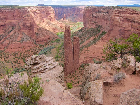 Spider Rock is in Canyon de Chelly National Monument, Chinle, Arizona. Chinle Creek in Canyon de Chelly is a tributary stream of the San Juan River in Apache County, Arizona. Its name is derived from the Navajo word ch'inili meaning 'where the waters came out'. May 2016.