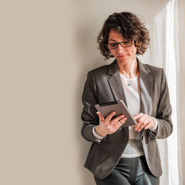 istock Woman with eyeglasses looking at tablet screen 1475129470