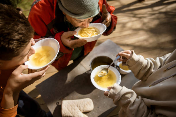 famiglia mangiare zuppa insieme - community outreach social worker teenager poverty foto e immagini stock