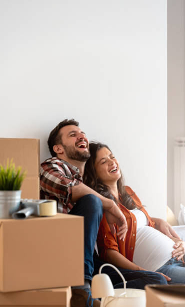 istock Young happy couple moved into an empty apartment sitting among cardboard boxes 1475130592