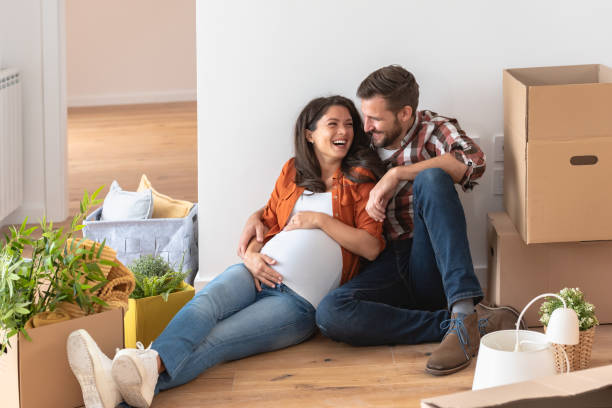 istock Young happy couple moved into an empty apartment sitting among cardboard boxes 1475130854