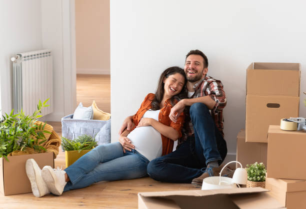 istock Young happy couple moved into an empty apartment sitting among cardboard boxes 1475130939