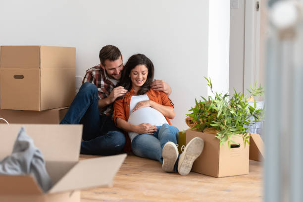 istock Young happy couple moved into an empty apartment sitting among cardboard boxes 1475130980