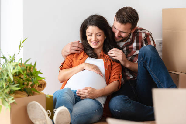 istock Young happy couple moved into an empty apartment sitting among cardboard boxes 1475131038