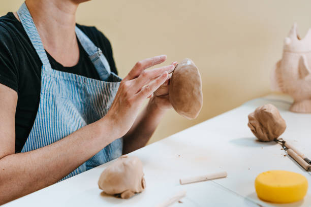 istock Young woman potter sculpting a cup at workshop 1475131998