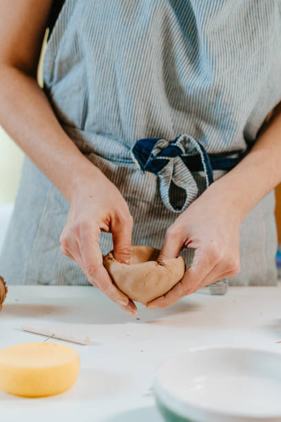 istock Close-up of female artisan sculpting a cup at workshop 1475131999
