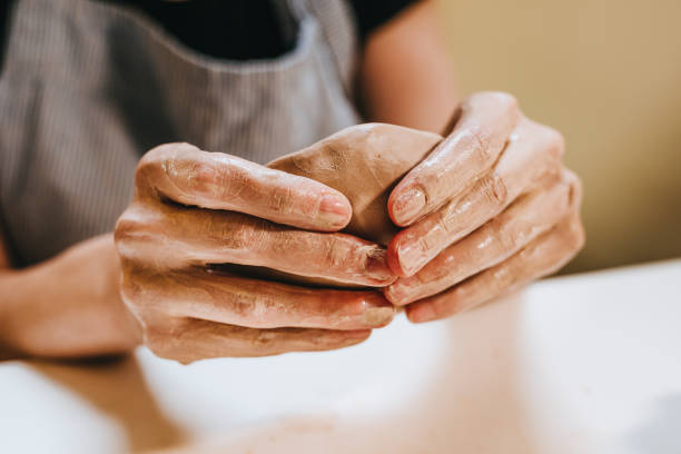 istock Young woman potter sculpts a cup at workshop. 1475132010