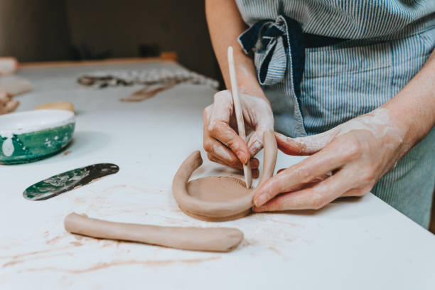 istock Young woman potter working with clay in a workshop 1475132055