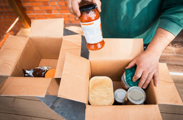 istock Senior Hands loading food to a donation boxes 1475132069
