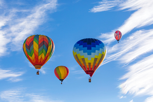 Colorful hot air balloons flying in the blue sky with white clouds