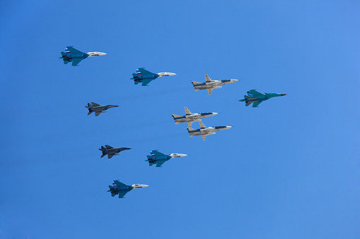 Fighter jets flying in formation over the clouds.