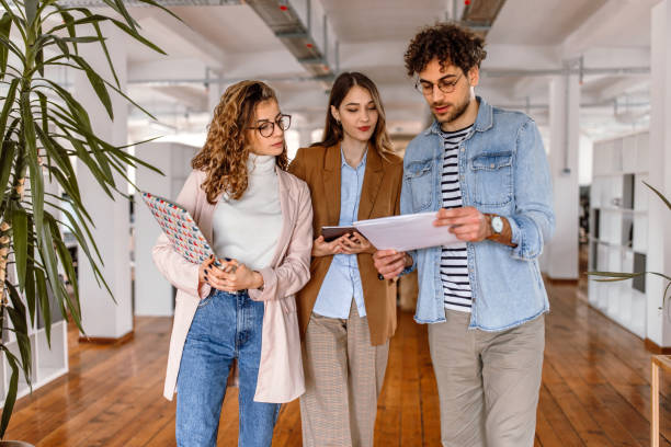 istock Group of coworkers standing in the office whyle analysing documents 1475137711
