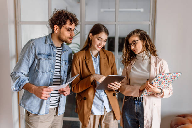 istock Group of coworkers standing in the office whyle analysing documents 1475138327