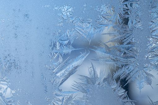 Close-up of icicles on a blue snowflake shaped bokeh background. It's a REAL bokeh photo, not an illustration or computer filter.