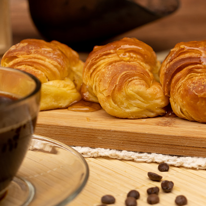 Croissants with jelly on wooden board in still life.
