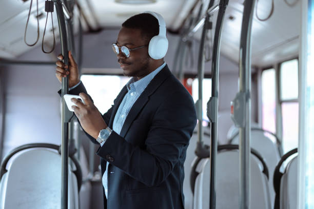 istock African-American commuter in public transport using video streaming service on smart phone 1475141000