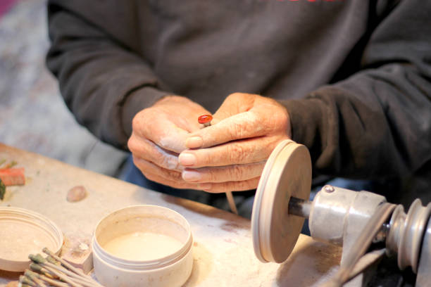 руки пожилого мастера, работающего в мастерской по полировке опаловых камней и минералов для формирования драгоценных украшений - senior hands flash стоковые фото и изображения