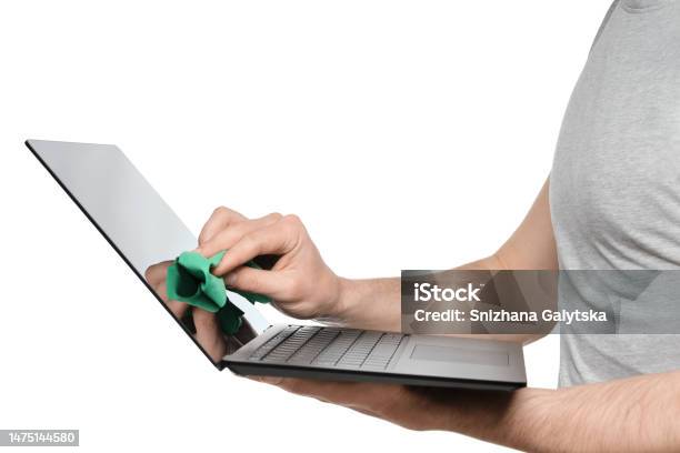A Man In A Gray Tshirt Wipes The Screen Of An Ultrabook Laptop With A Green Rag Stock Photo - Download Image Now