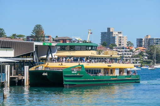The Sydney ferry, Fairlight, as she arrives with passengers at Manly Wharf from Circular Quay.  This image was taken from the promenade above the harbour-side beach on a sunny and windy afternoon on 11 February 2023.