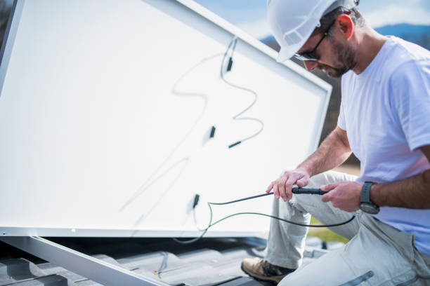 istock Solar panel installer installing solar panels on roof of modern house. 1475150437