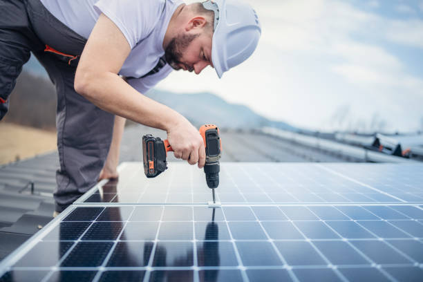 istock Solar panel installer installing solar panels on roof of modern house. 1475150443