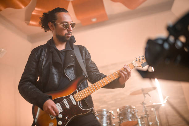 istock Hispanic Guitarist Recording Music in Recording Studio 1475153022