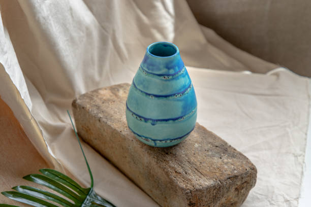 istock Blue handmade ceramic vase on white textured table cloth. 1475153102