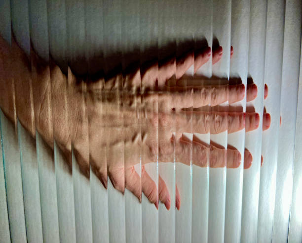 Hand with backlighting viewed through corrugated glass. Direct view of a hand with back light through fluted glass on white background. Distorted image of hand by vertical stripes corrugated glass. Abstract illusion. frosted glass door office stock pictures, royalty-free photos & images
