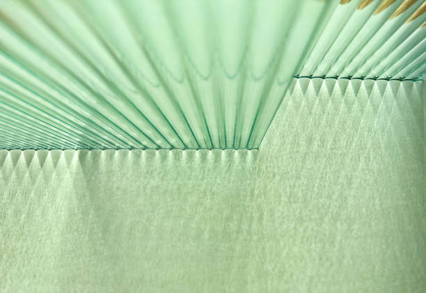Double layers of reeded glass refract natural light into combination of shade and shadow. Refraction of light through double layers of corrugated and fluted glass creating triangular shadow stripes on white paper vertical wall. Criss cross shadow pattern combination of shade and shadow. frosted glass door office stock pictures, royalty-free photos & images