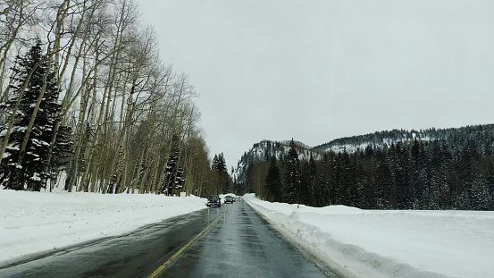 Western Colorado Mountain Road with Seasonally Deep Snow Banks in Late Winter Snow Storms in Grand Mesa National Forest Photo Series - Matching Video in Portfolio