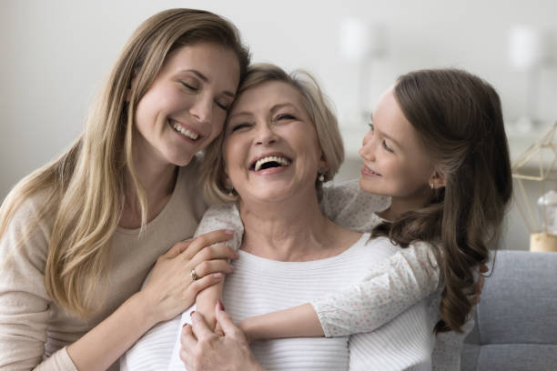 Joyful grandkid girl and daughter woman hugging happy excited grandma Joyful grandkid girl and adult daughter woman hugging happy excited grandma, celebrating birthday, mothers day, smiling, laughing, having fun, enjoying family meeting, warm relationships elderberry photos stock pictures, royalty-free photos & images