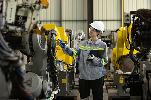 Female engineer checking and record data machine to clipboard