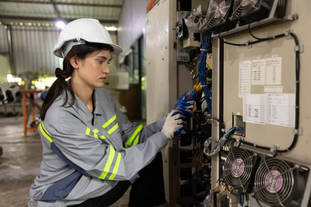 istock Female engineer using electric measurement tool measuring control panel in factory 1475163372