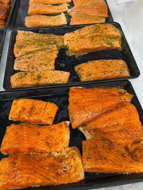 Assorted marinated salmon fillet pieces now available at the fish market