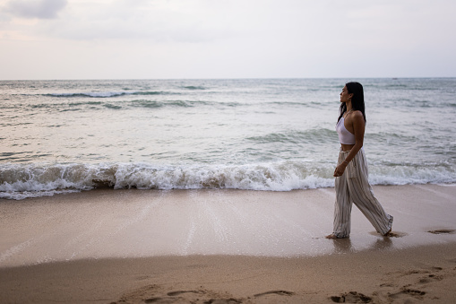 Transgender Asian woman woman walking on the beach by the sea.