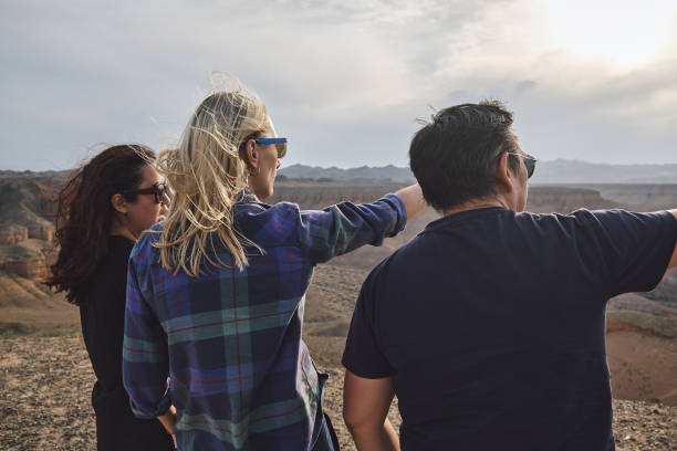 istock Three people looking to the Grand Canyon from a viewpoint, windy 1475171481