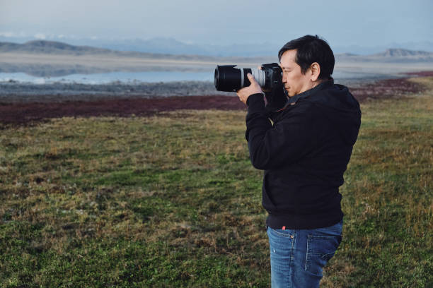 istock Man nature photographer with a camera shoots a landscape 1475171509