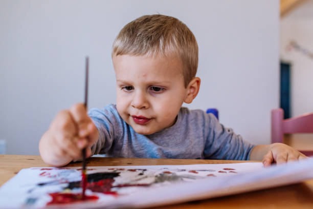 istock focused toddler boy painting inside 1475171615