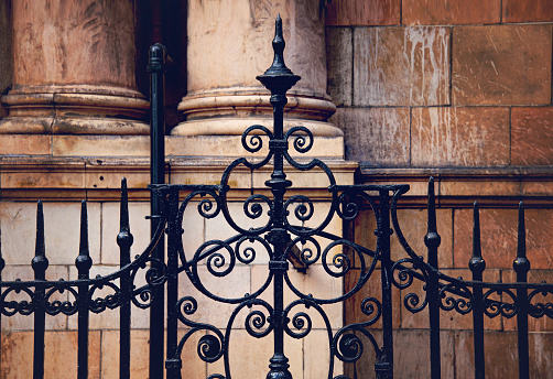 The intricate design of the fence, with its swirling patterns and delicate curves, speaks to the craftsmanship and attention to detail that was so prevalent in the past.