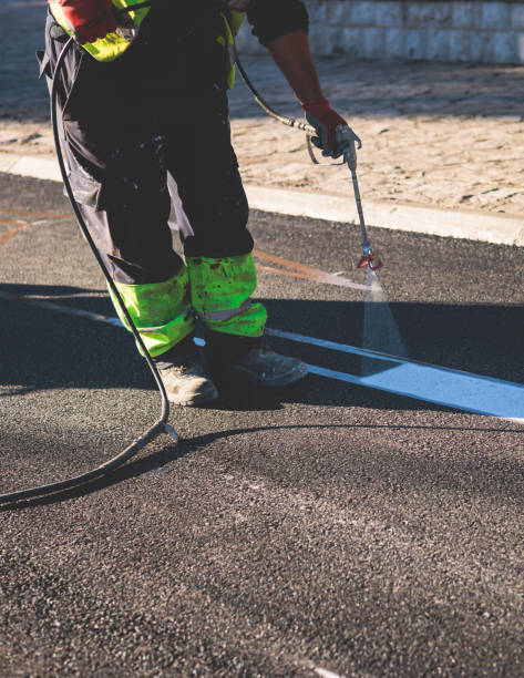 istock Process of making new road surface markings with a line striping machine, workers improve city infrastructure, demarcation marking of pedestrian crossing with a hot melted paint on asphalt pavement 1475179543