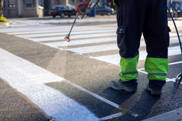 istock Process of making new road surface markings with a line striping machine, workers improve city infrastructure, demarcation marking of pedestrian crossing with a hot melted paint on asphalt pavement 1475179639