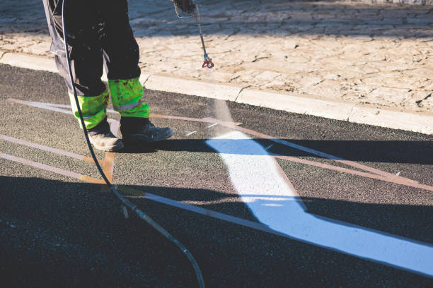 istock Process of making new road surface markings with a line striping machine, workers improve city infrastructure, demarcation marking of pedestrian crossing with a hot melted paint on asphalt pavement 1475179640