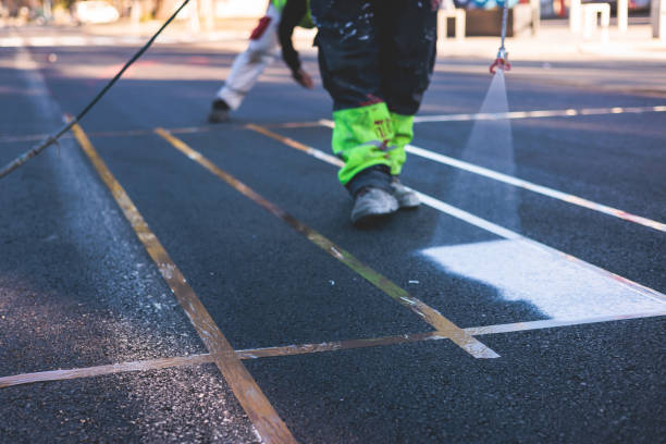 istock Process of making new road surface markings with a line striping machine, workers improve city infrastructure, demarcation marking of pedestrian crossing with a hot melted paint on asphalt pavement 1475179818