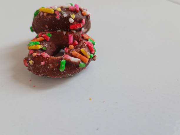 istock Close up of glazed doughnuts with bright colored sprinkles 1475183815