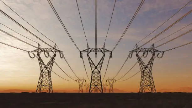 The silhouette of the high voltage power lines during sunset.