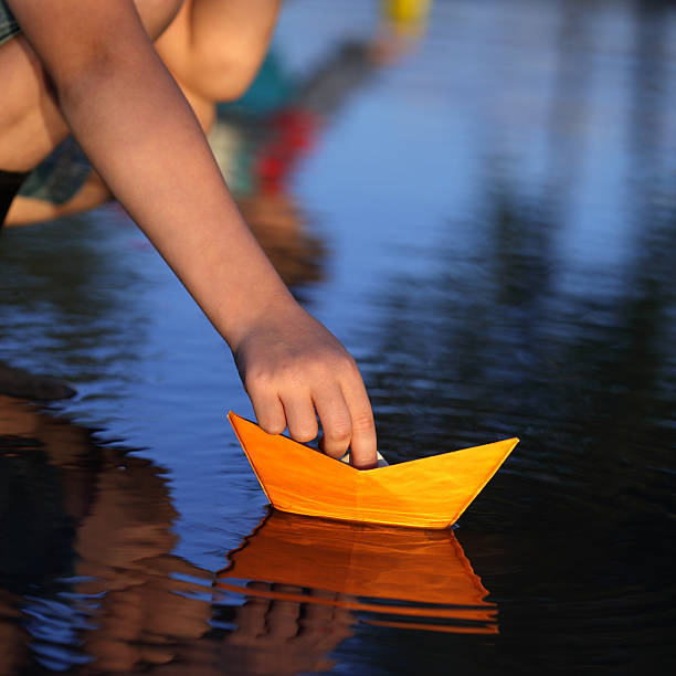 istock paper ship in children hand 147518598